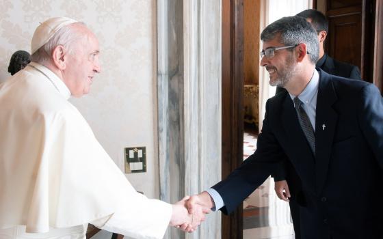 The pope shown shaking Correa's hand.