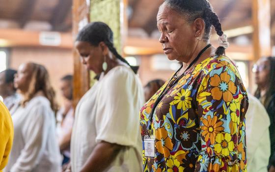 From left, family members Bernadette Semple (in the background), Toni Ann Semple and Denise Semple pray during Mass Sept. 3, 2023, at St. Peter Claver Church in St. Inigoes, Md. The Mass closed the Southern Maryland GU272 — Jesuit Enslaved Descendant Gathering Aug. 31-Sept. 3. (OSV News/Catholic Standard/ Mihoko Owada)