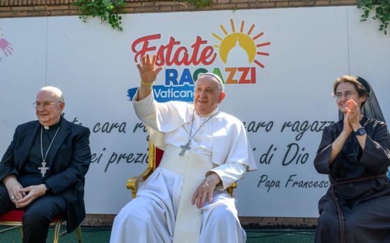 Pope sits in middle smiling and waving, Alzaga on left and Petrini on right.