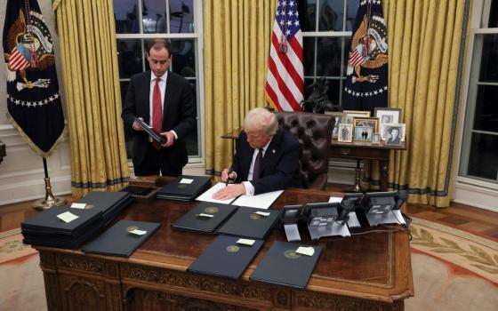 The president shown sitting at desk. 