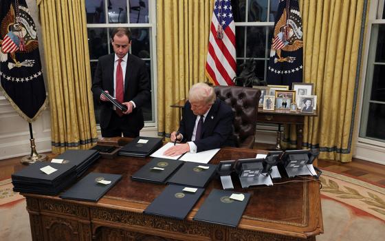 U.S. President Donald Trump signs an executive order in the Oval Office of the White House, in Washington on Jan. 23. (OSV News/Reuters/Carlos Barria)