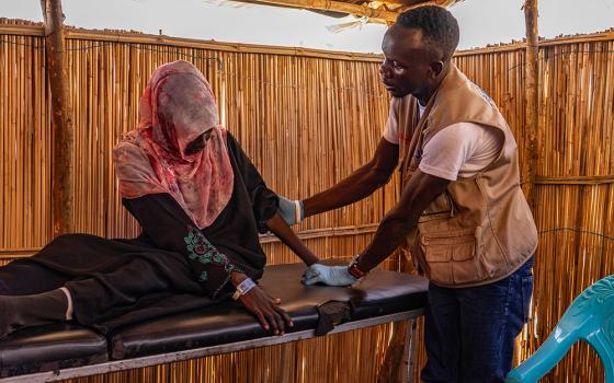 A worker with Jesuit Refugee Service seen in a 2023 photo offers physical therapy to a woman in Renk, South Sudan, as part of the response to the conflict in Sudan. A pause on U.S. foreign aid is affecting critical programs carried out by nongovernmental organizations like JRS. (OSV News/Courtesy JRS)