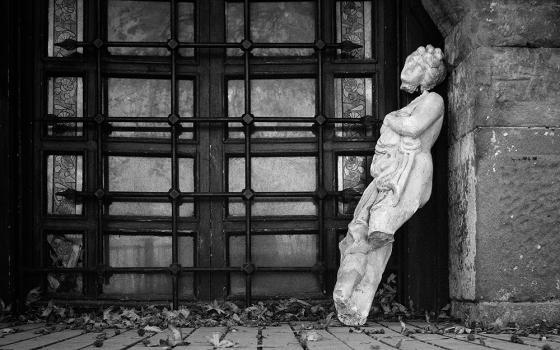 A broken statue sitting against a wall (Unsplash/Dmitry)