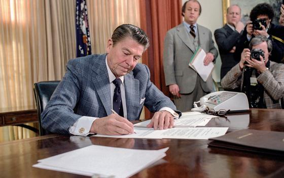 President Ronald Reagan signs an executive order on reductions in government spending in the Oval Office in the White House in Washington, D.C., on Jan. 22, 1981, two days after his inauguration. (U.S. National Archives and Records Administration)