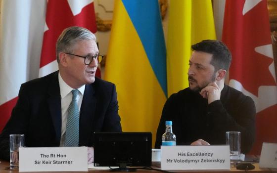 Starmer and Zelenskyy sit side by side on panel.