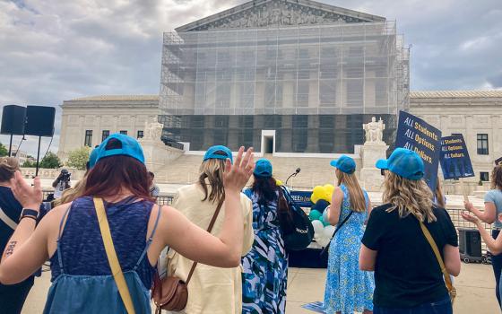 Demonstrators in front of the Supreme Court join in song during a rally to support St. Isidore of Seville Catholic Virtual School in Oklahoma in its fight for approval from the U.S. Supreme Court for state taxpayer support. (NCR photo/Carol Zimmermann)