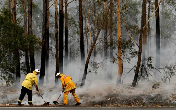 Firefighters contain a bushfire along a highway near Ulladulla, Australia, Jan. 5. (CNS/Reuters/AAP/Dean Lewins)