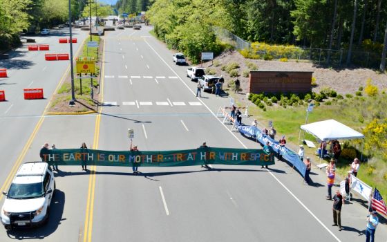 Protesters hold a banner while blocking the Main Gate entrance to Naval Base Kitsap-Bangor May 12 as part of a protest against the Trident submarine base in honor of Mother's Day for Peace. (Ground Zero Center for Nonviolent Action/Glen Milner)