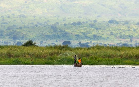 Two fishermen throw a net out on Lake Albert in Uganda. (Dreamstime/Mathias Sunke)