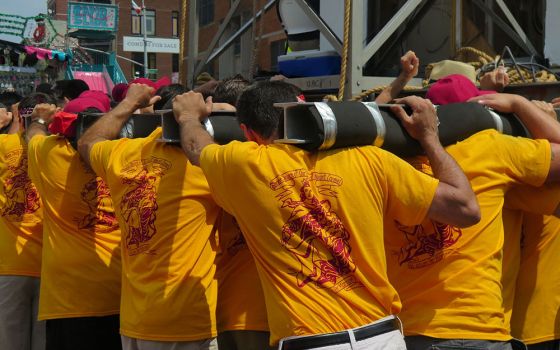 Men carry the 1-ton steel tower during the 2015 giglio parade in Williamsburg, Brooklyn, New York. (Dreamstime/Rebekah Burgess)