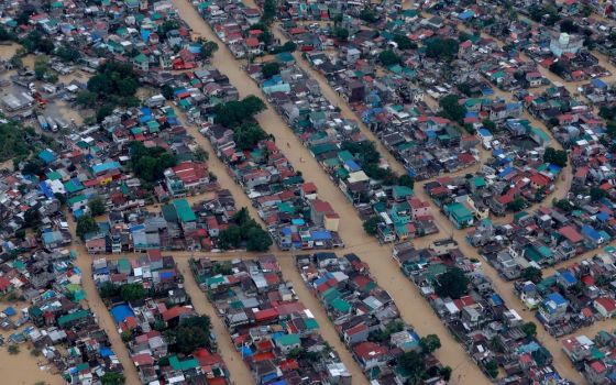 Floodwaters surround homes in Manila, Philippines, following Typhoon Vamco in 2020. Besides being battered by increasingly severe storms, the city is at serious risk from rising sea levels, bishops warn. (CNS photo/Presidential handout photo via Reuters) 