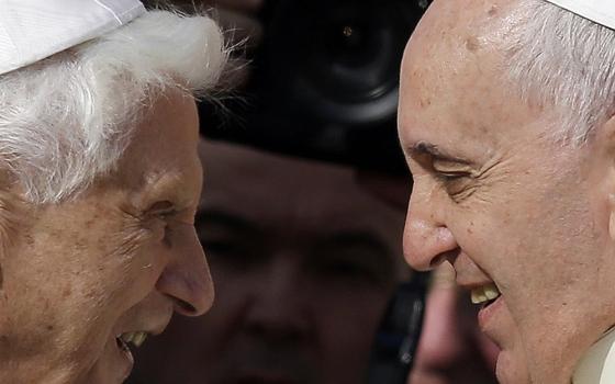 Pope Francis greets Pope Emeritus Benedict XVI prior to the start of a meeting with elderly faithful in St. Peter's Square at the Vatican, on Sept. 28, 2014.