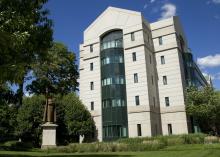 A tall, modern stone and glass building. 