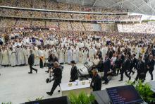 Faithful wait in the Singapore SportsHub National Stadium where Pope Francis will preside over a mass 'In Memory of the Most Holy Name of Mary' celebrated by the Archbishop of Singapore, Cardinal William Goh Seng Chye, center right, Thursday, Sept. 12, 2024. Pope Francis has praised Singapore's economic development as a testament to human ingenuity. But he's urging the city-state to look after the weakest too. Francis made the remarks Thursday on the final leg of the longest and farthest tour of his papacy.