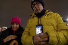 A man holds his phone displaying an image of Pope Francis as he joins Cardinal Pietro Parolin, Vatican secretary of state, in reciting the rosary for the pope in St. Peter's Square at the Vatican Feb. 24, 2025. Cardinals living in Rome, leaders of the Roman Curia and the faithful joined the nighttime prayer. (CNS photo/Pablo Esparza) 