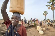 A woman carries water from a well in Lugi, a village in the Nuba Mountains of Sudan. (CNS photo/Paul Jeffrey)